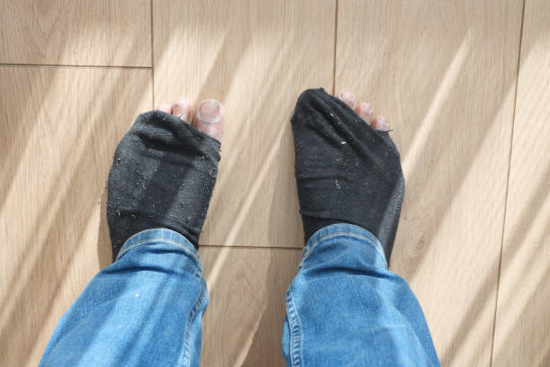 men feet with dirty socks while sitting on sofa .