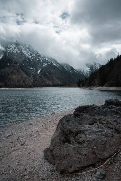 istock Rocky Lakeshore with Snow-Capped Mountains 2183061062