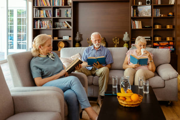 istock Elderly People Reading a Book While Sitting in the Living Room 2183062330