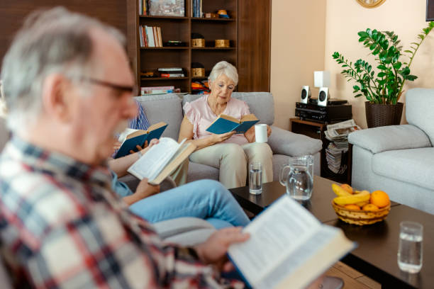 istock Elderly People Reading a Book While Sitting in the Living Room 2183062408
