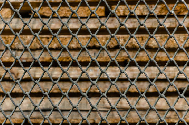 Old rusty wire mesh and old wooden sheets in the background