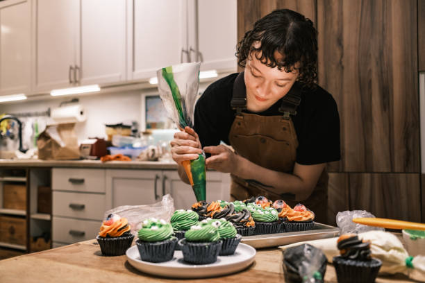 istock Young woman making Halloween cup cakes in the kitchen 2183071803