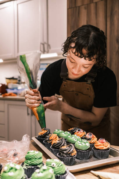 istock Young woman making Halloween cup cakes in the kitchen 2183071826