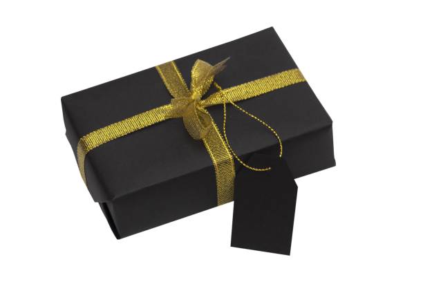 istock Black gift box with gold ribbon and tag isolated on white background. Black Friday concept 2183072206