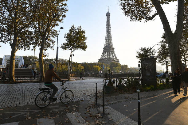 Paris, France-11 04 2024: Cyclist on a street in Paris, passing in front of the Eiffel Tower, France.