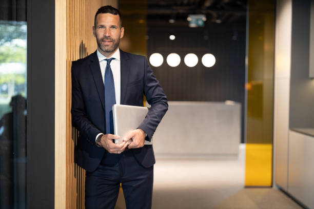 istock Confident CEO leaning against the wall in a modern office 2183079121