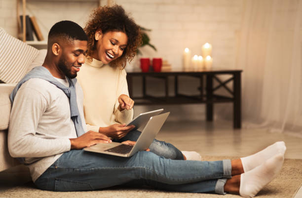 istock Relaxed afro couple browsing internet on laptop and tablet 2183083201