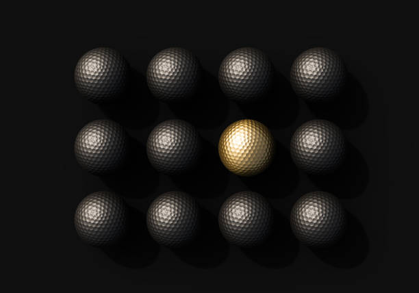 Extreme close up of a white golf ball, strong side-light is casting shadows across the balls dimples