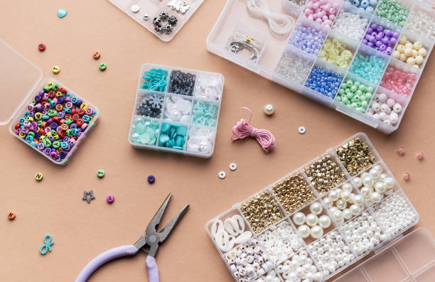 istock Crafting with colorful beads on a flat workspace with tools and containers in bright daylight 2183084261