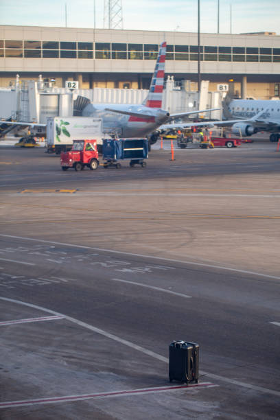 Passenger checked-in luggage waiting on the ramp to be loaded at Dallas Fort Worth International Airport in Jan 2024