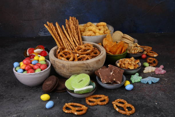 istock Salty snacks. Pretzels, chips, crackers in wooden bowls on table 2183087210
