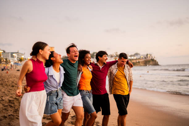 istock Young friends talking and walking on the beach 2183090838