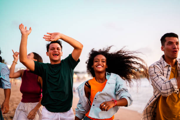 istock Young friends dancing and walking on the beach 2183090865