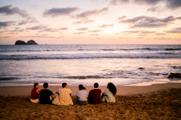 istock Young friends relaxing and talking on the beach 2183090875