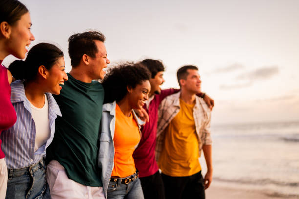 istock Young friends talking and walking on the beach 2183091374