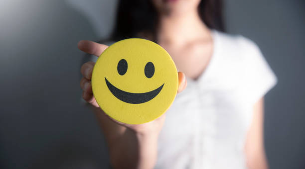 istock young girl holding smiley face on her hand 2183091773