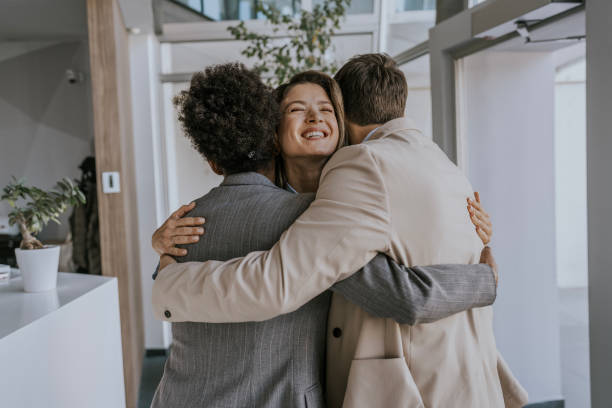 istock Happy business colleagues hugging in modern office lobby 2183092392