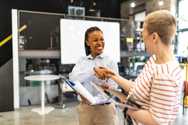 istock Cheerful businesswomen shaking hands in modern office 2183092934
