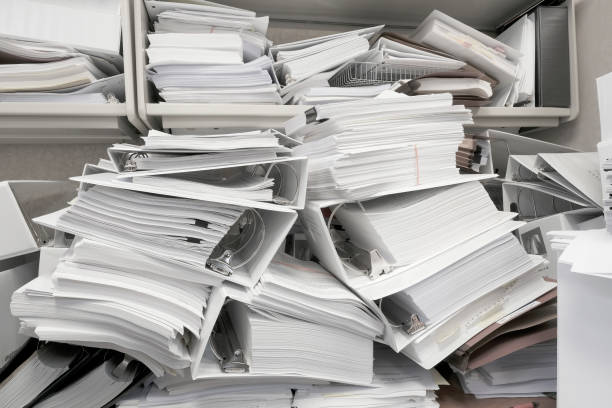 istock Messy Office Pile of Binders with Papers Filing Disorganized Mess 2183093548