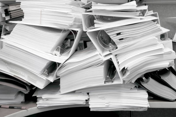 Messy Office Pile of Binders with Papers Filing Disorganized Mess