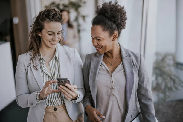 istock Two businesswomen discussing content on smartphone in modern office 2183094069