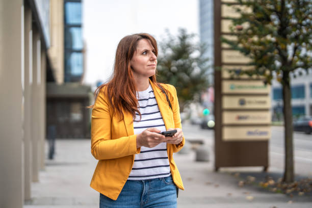 istock Professional Woman Networking on Smartphone Outdoors 2183096716