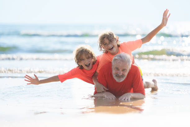 istock Grandfather and kids on summer beach 2183099341