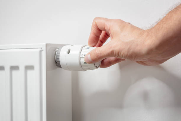 Adjusting temperature on radiator thermostat central heating control adjustment background