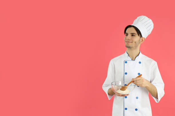 istock Concept of cooking, young male chef on pink background 2183100206