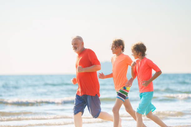 istock Grandfather and kids on summer beach 2183100456