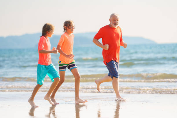 istock Grandfather and kids on summer beach 2183100649