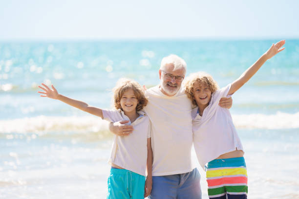 istock Grandfather and kids on summer beach 2183100720