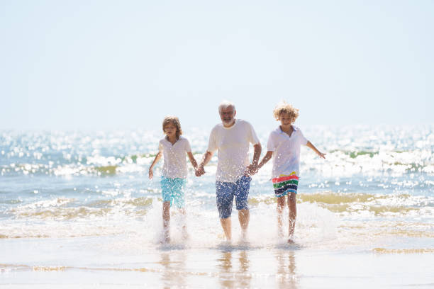 istock Grandfather and kids on summer beach 2183100911