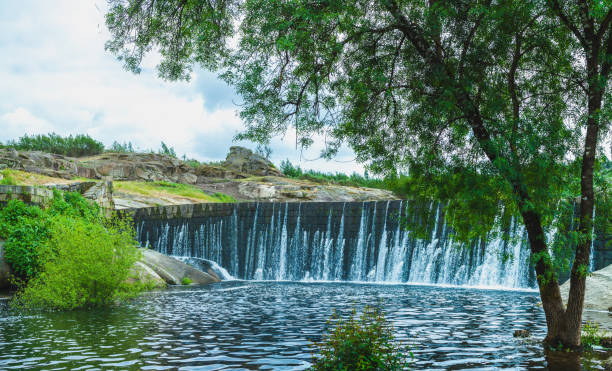 stone dam over which water flows in gentle cascades