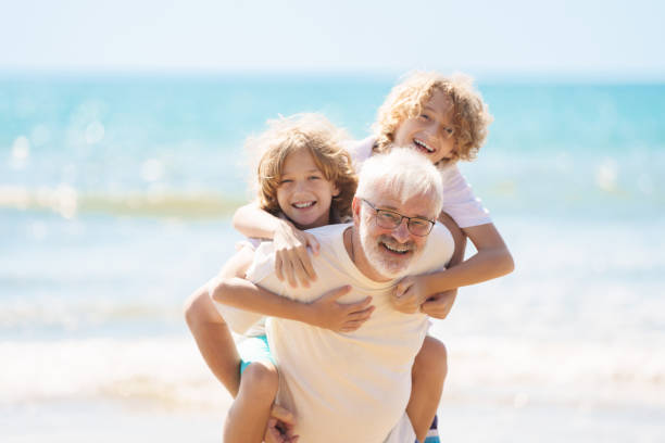 istock Grandfather and kids on summer beach 2183101622