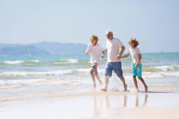 istock Grandfather and kids on summer beach 2183101754