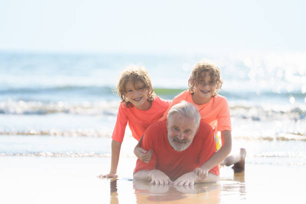 istock Grandfather and kids on summer beach 2183101863
