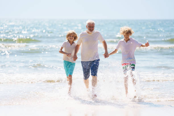 istock Grandfather and kids on summer beach 2183102120