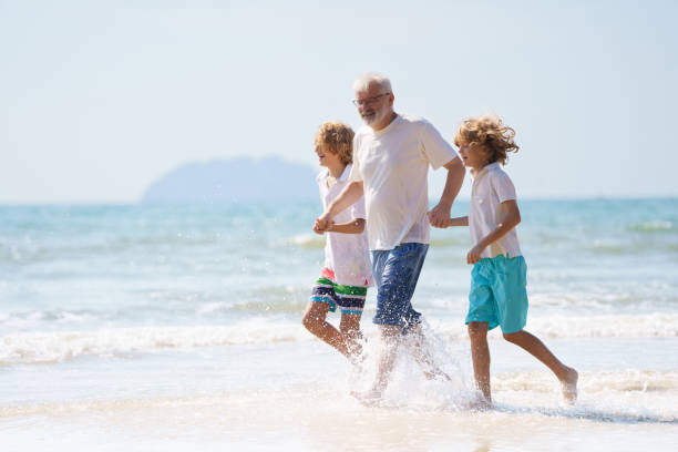 istock Grandfather and kids on summer beach 2183102417