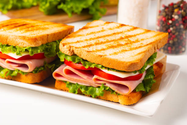 Whole wheat bread toast, sliced cheese and turkey on natural wooden tray