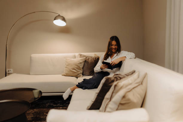 istock Woman reading book at home at night 2183105168