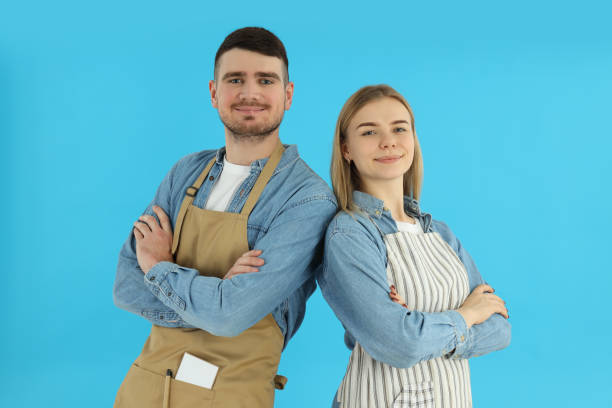 istock Young waiter and waitress on blue background 2183105632