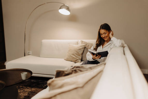 istock Woman reading book at home at night 2183105723