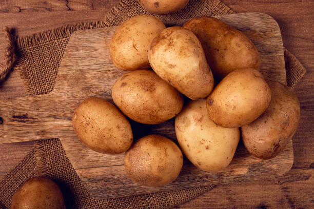 istock Raw potatoes, scattered on a chopping board, close-up, no people, 2183109250