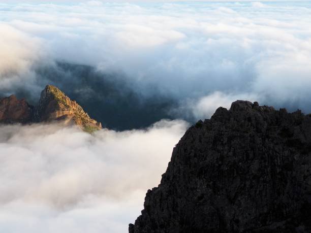 istock Mountain peaks emerge dramatically through an expansive cloud layer during a foggy morning, presenting a mystical and ethereal vision of natural beauty and wonder - Pico do Arieiro, Madeira, Portugal. 2183109478