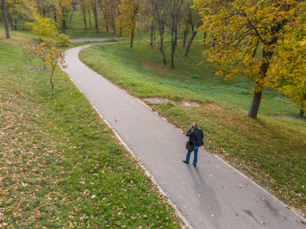 Businessman in hurry using mobile phone while walking outdoors in the city