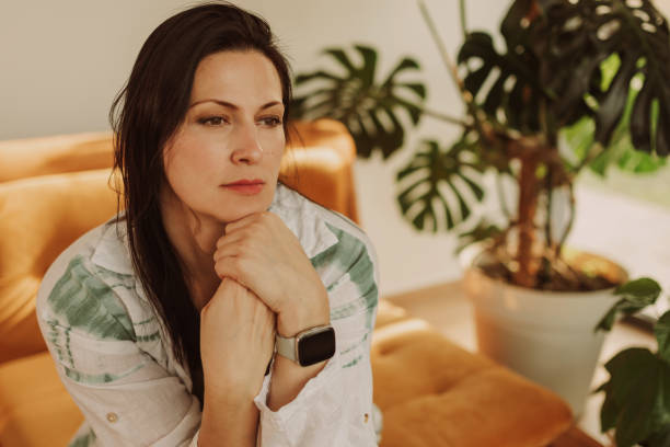 istock Thoughtful Woman Relaxing in a Cozy Room With Plants 2183114209