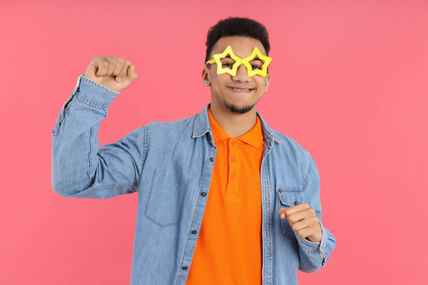 istock Young man in star glasses on pink background 2183114899