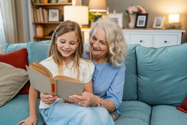 istock Grandmother with granddaughter reading book 2183115797