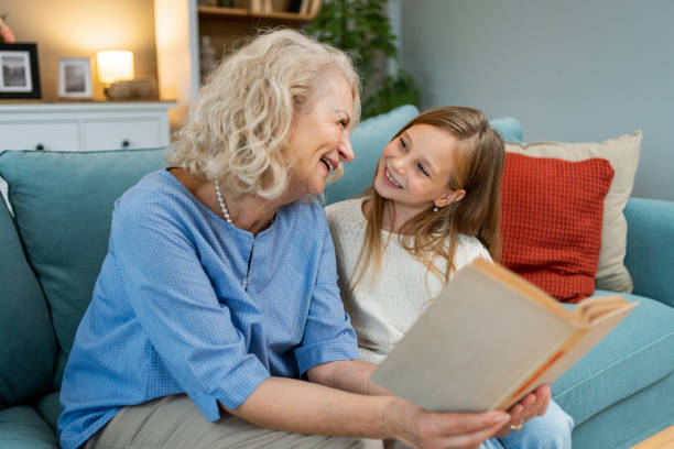 istock Cute granddaughter reading a book with her grandma 2183116079